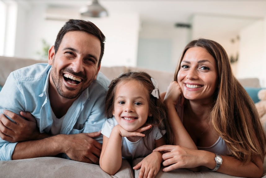 mom, dad, and daughter smiling on the couch in federal way