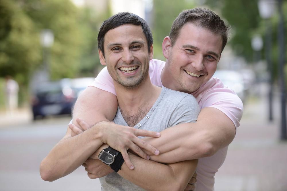 a male couple hugging and smiling