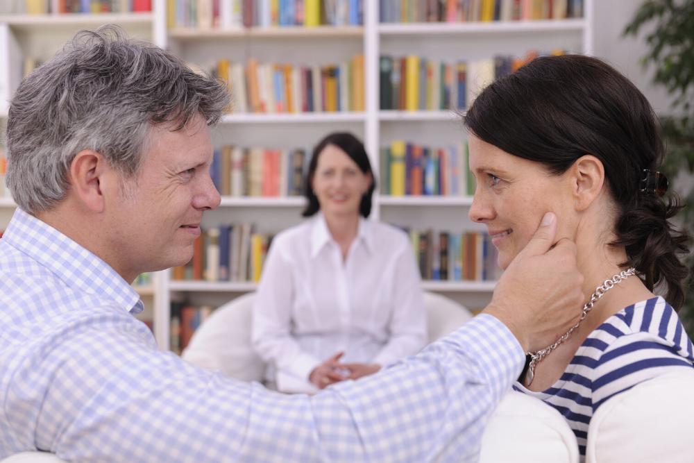 man lovingly touching woman's cheek during therapy