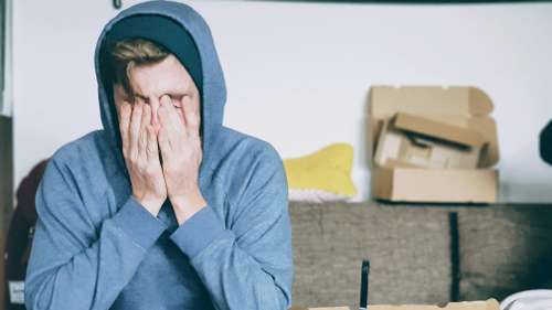 stressed individual with hands over their face