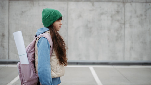 young girl with backpack going to school