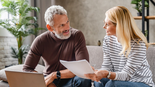 man and woman talking on couch 