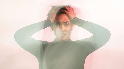 woman holding head from anxiety