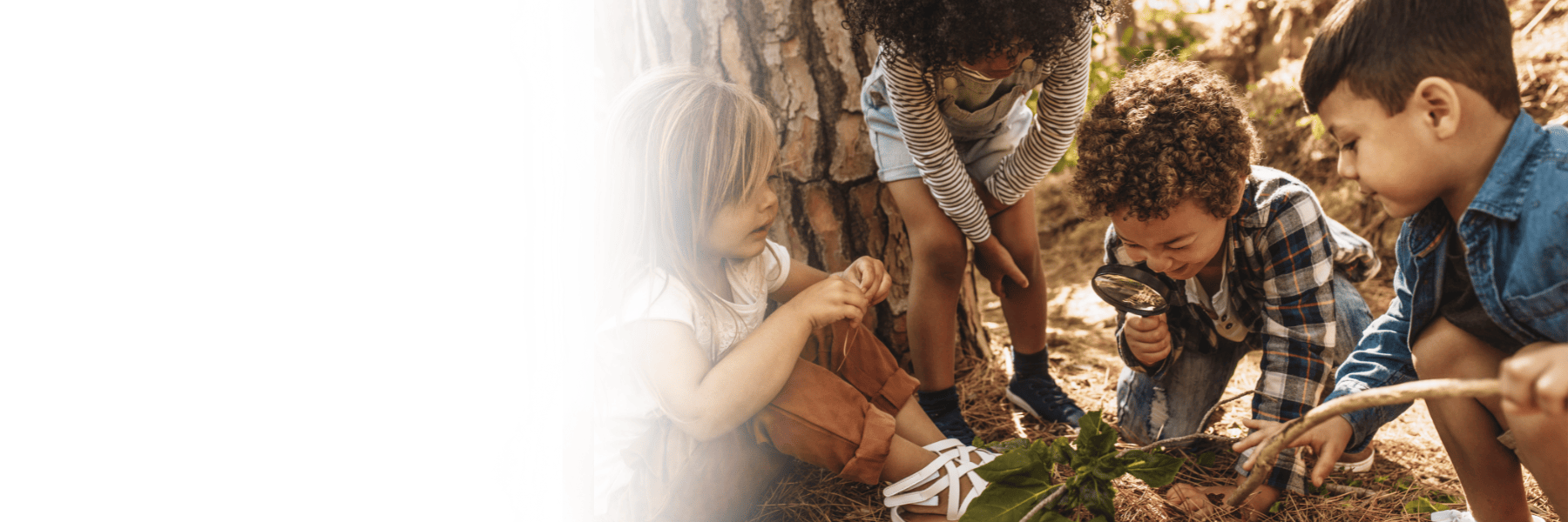 kids using a magnifying glass to look at leaves